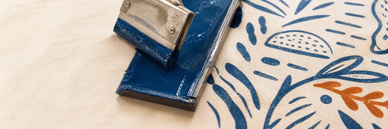 Rasqueta con tinta azul sobre algodón estampado