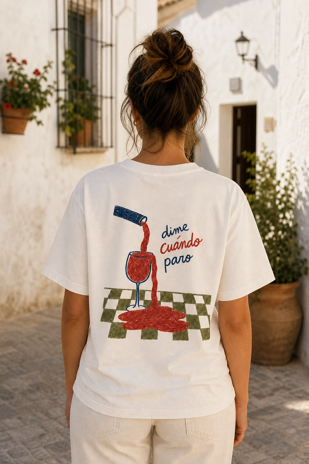 Chica de espaldas con la camiseta Dime Cuándo en una calle andaluza